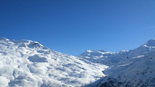 Snowcapped mountains against clear blue sky