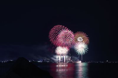 Low angle view of firework display against sky at night