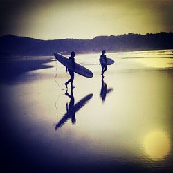 Tourists on beach at sunset