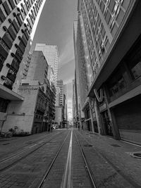Low angle view of man walking on railroad