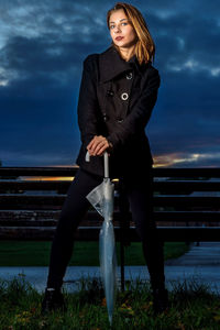 Portrait of young woman standing against sky