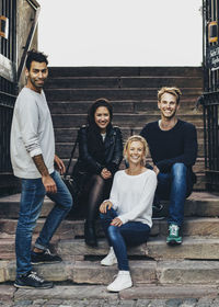 Portrait of happy multi ethnic friends on steps