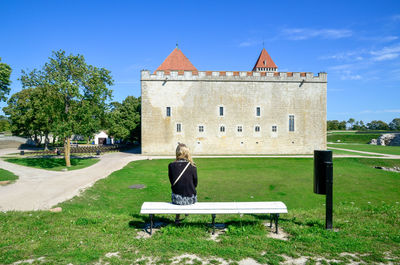 Rear view of woman sitting on bench