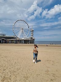 Ferris wheel at beach against sky