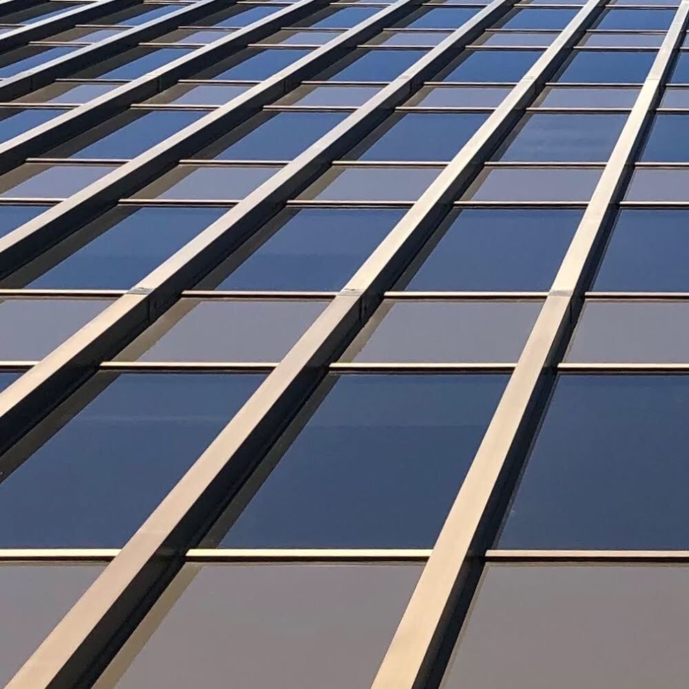 LOW ANGLE VIEW OF MODERN GLASS BUILDING