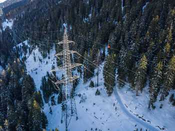 High angle view electrical pylon on snow covered land