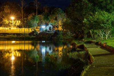 Illuminated street by lake at night