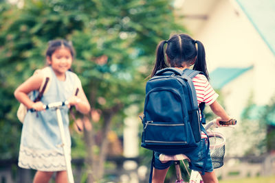 Rear view of schoolgirl riding bicycle