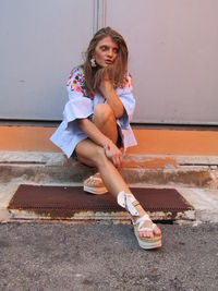 Portrait of a girl sitting on wall