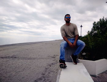 Young man on sunglasses against sky