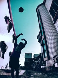 Low angle view of man and buildings against sky