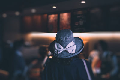 Person wearing hat in cafe at night