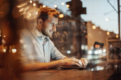 Portrait of man using smart phone in restaurant