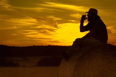 Silhouette of people on landscape at sunset