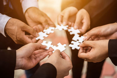 Cropped image of man holding jigsaw piece