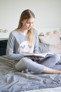 Young woman using phone while sitting at home