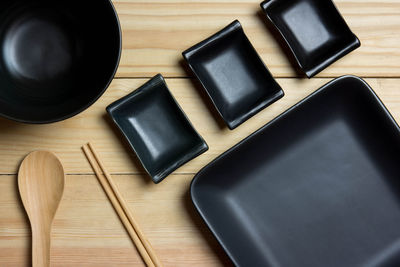 Black plates and black bowl are empty.