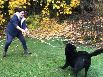 Woman with dog against plants