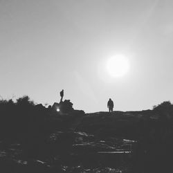 Silhouette man standing on landscape against clear sky during sunset