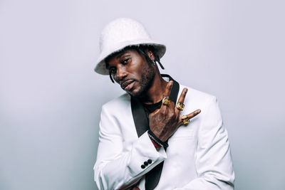 Young man wearing hat standing against white background