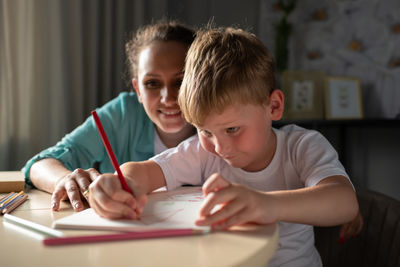 Mother helping son to draw