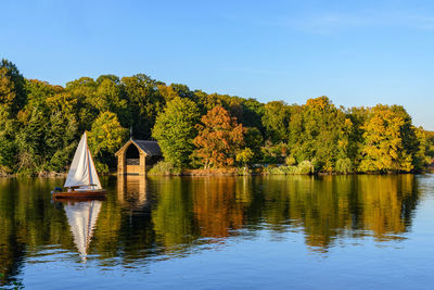 Scenic view of lake by trees against sky