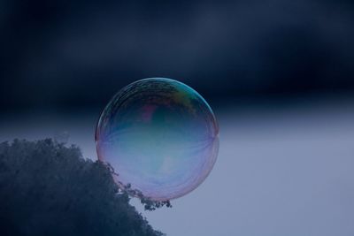 Low angle view of bubbles against rainbow in sky