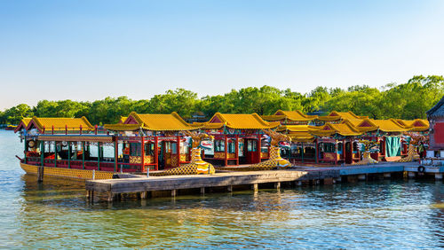 Buildings by river against clear sky