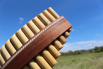 Low angle view of stack on field against blue sky