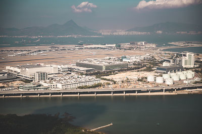 High angle view of city by river against sky