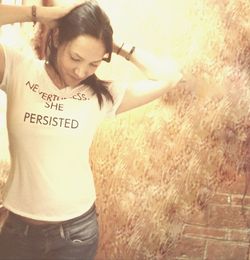 Portrait of smiling young woman standing by text