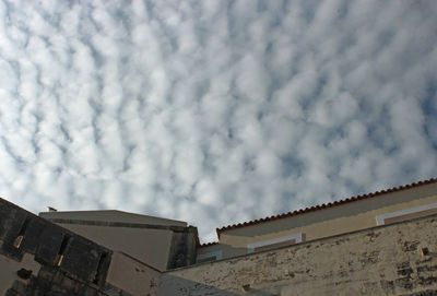 Low angle view of building against cloudy sky