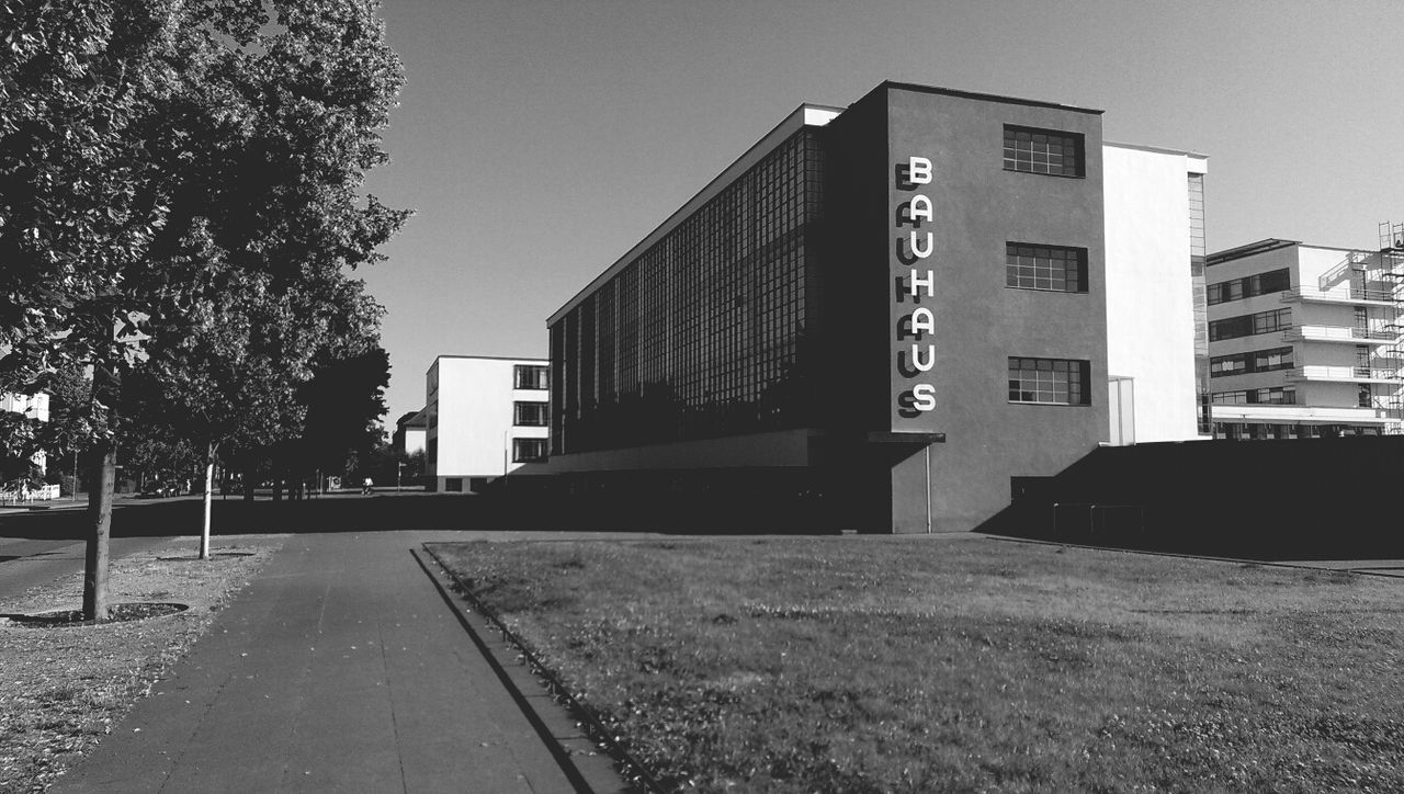 building exterior, architecture, built structure, clear sky, street, transportation, road, building, city, the way forward, sky, residential building, residential structure, car, day, outdoors, no people, empty, road marking, tree