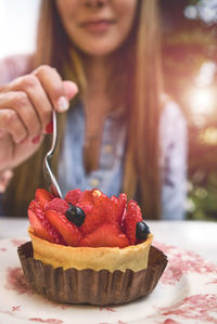 Midsection of woman holding cake