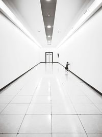 Rear view of man walking in illuminated building