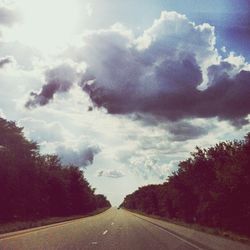 Empty road against cloudy sky