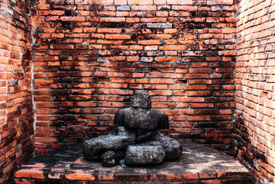 Statue against brick wall