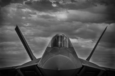 Military airplane against cloudy sky