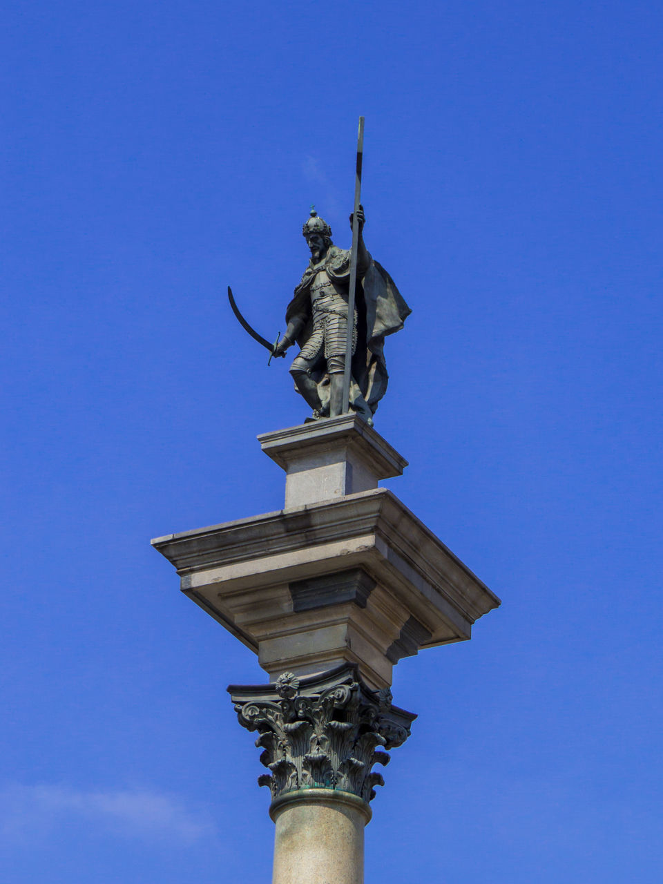 sculpture, sky, statue, blue, architecture, human representation, clear sky, low angle view, representation, no people, nature, history, the past, day, travel destinations, built structure, street light, landmark, outdoors, memorial, monument, craft, city, travel, sunny, male likeness