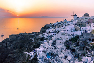 Houses by sea during sunset at santorini