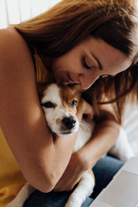 Portrait of young woman with dog at home