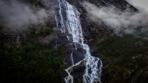 Low angle view of waterfall on rocks