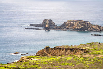 Rock formations by sea against sky