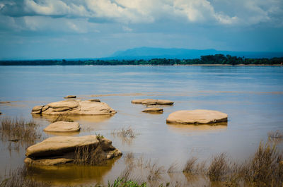 Scenic view of rocks in lake against sky