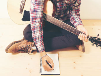 Low section of man playing guitar