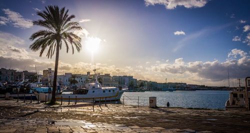 Boats moored at harbor against sky