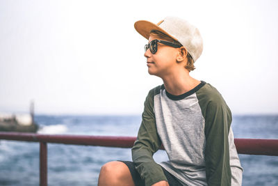 Mid adult man looking away in sea against sky