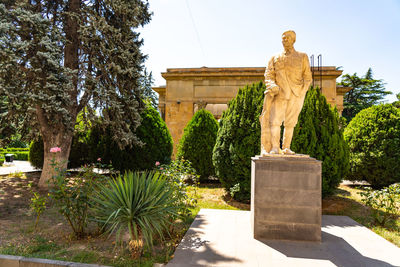 Statue in garden against sky