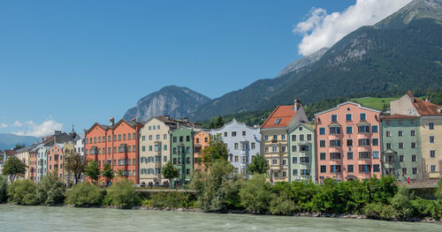 Buildings by mountains against sky