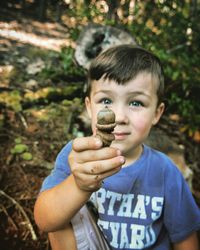 Close-up portrait of boy holding acorn